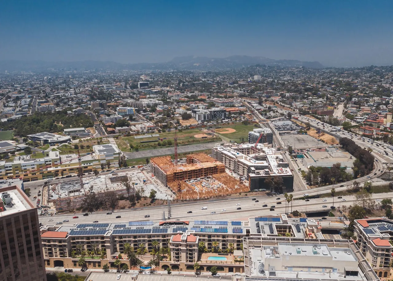 New apartment buildings going up beside a Los Angeles freeway, with the Hollywood Hills behind